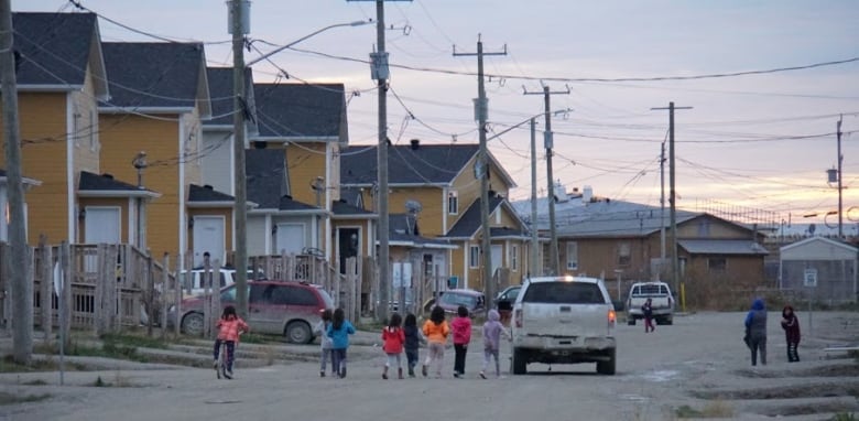 Kids on a street lined with houses