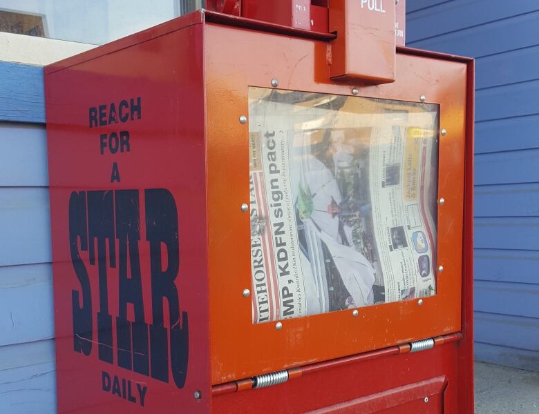 A newspaper box on the street.