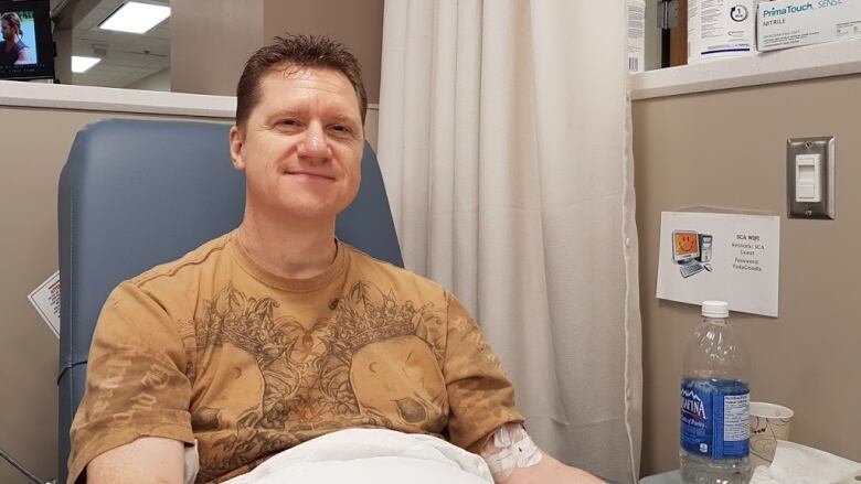 A man reclines in a medical chair.