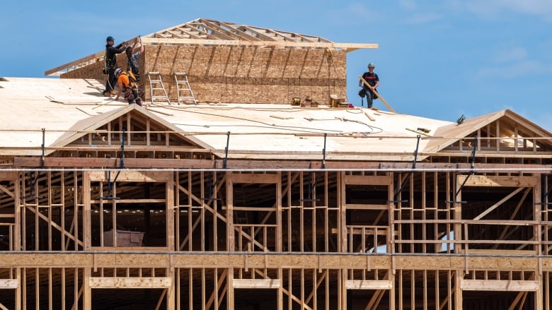 People stand on the roof of a building under construction.