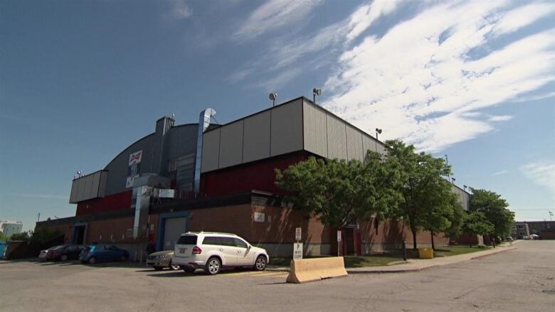 A brick arena building in a parking lot.