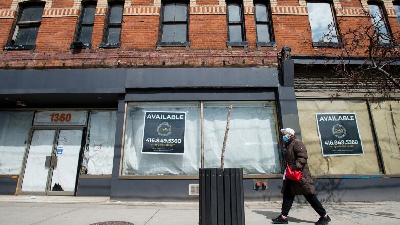 Closed store fronts on a Toronto street are boarded up with 