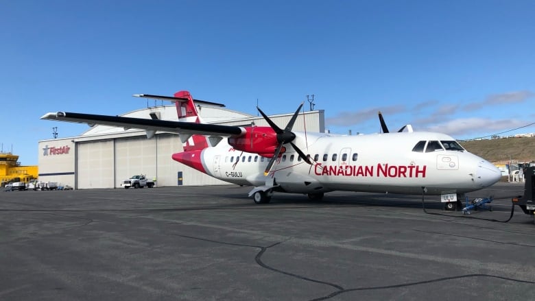 A small airplane labelled 'Canadian North' is seen on a tarmac.