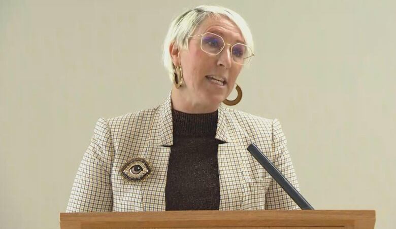 A woman speaks at a podium.