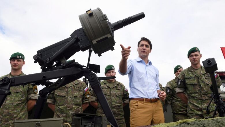 Trudeau gestures while visiting NATO troops at Adazi Military Base in Latvia, in 2018, where Canadian soldiers were stationed.