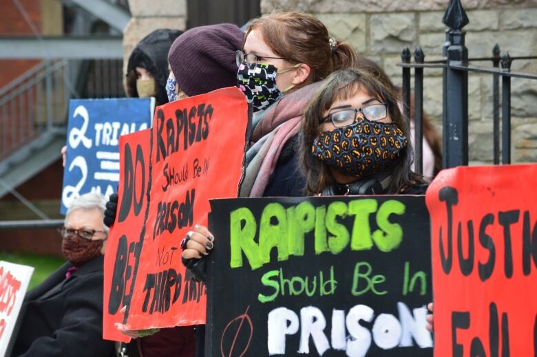 People holding signs outside court