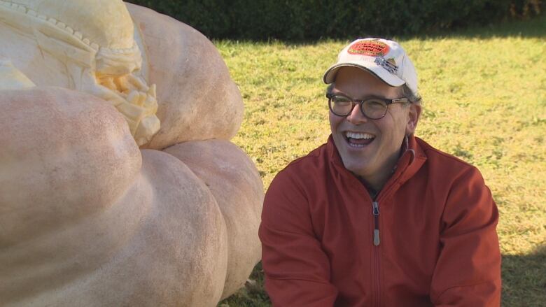 Man in front of a giant pumpkin