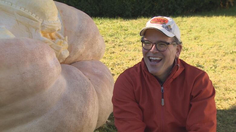 Man in front of a giant pumpkin