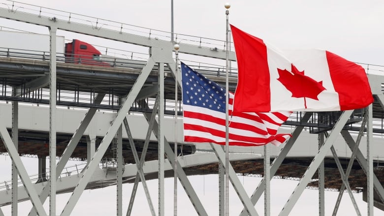 Canadian and American flags fly at the border