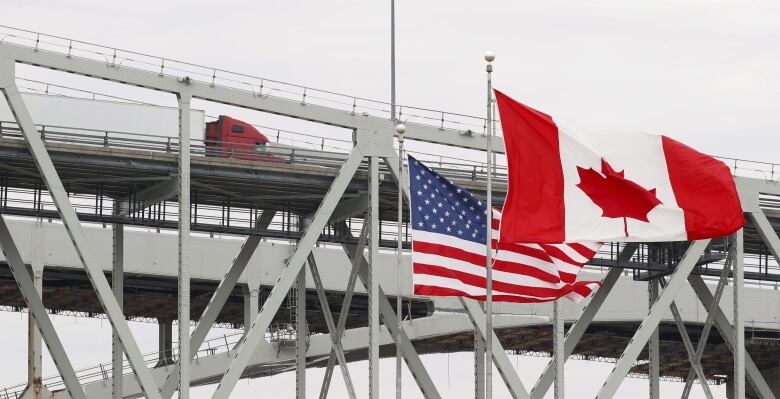 Canadian and American flags fly at the border.