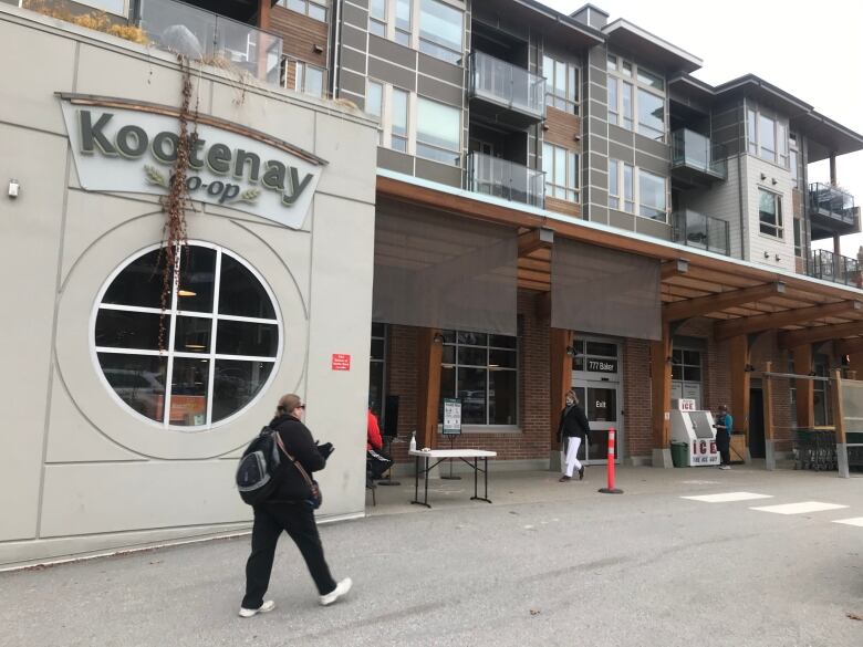 A pedestrian walks past a store featuring the sign 