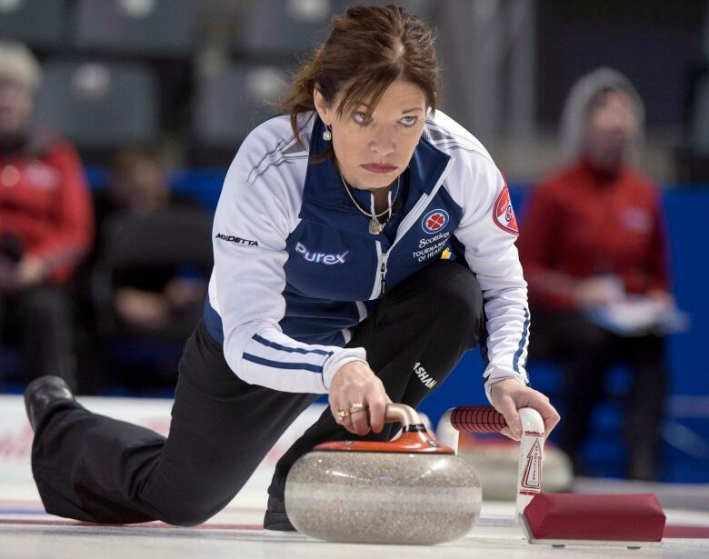 A woman is seen curling.