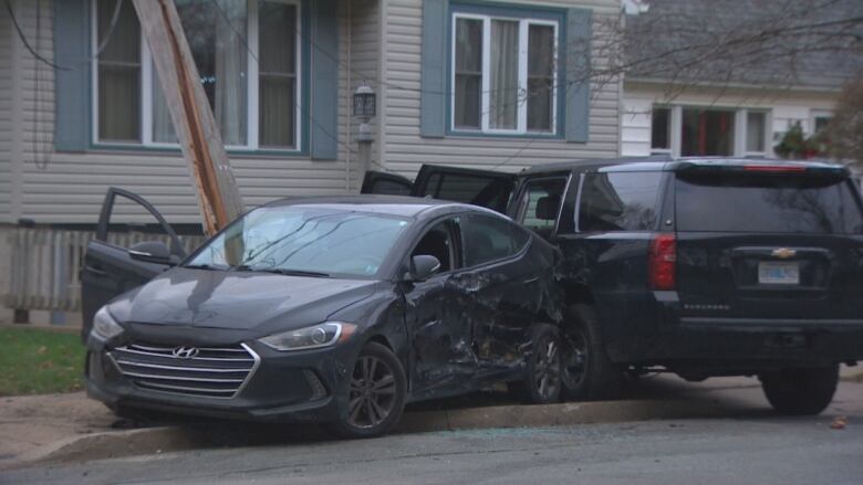 smashed up black car near utility pole