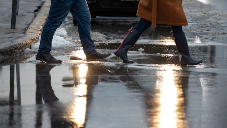 People walk through a puddle.