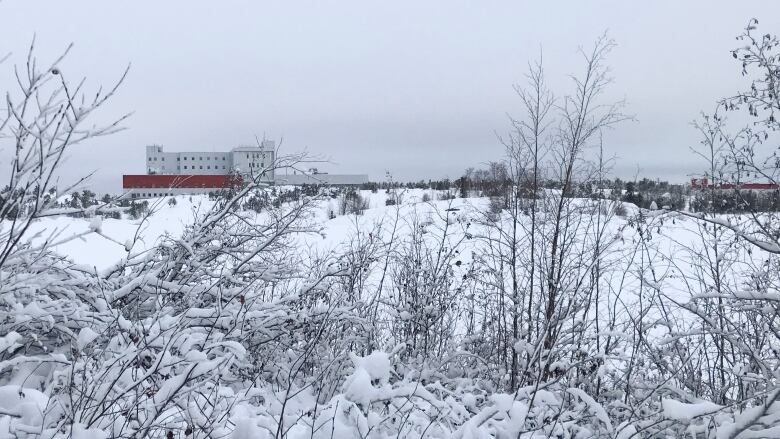 A snowy lake with a building in the distance.