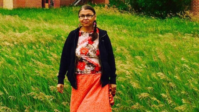 A woman on an orange dress in a field 