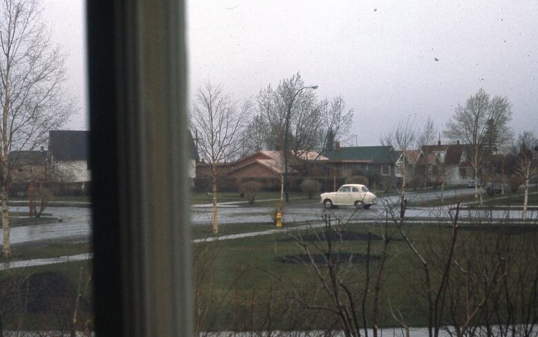 A historic photo from 1959 shows a vehicle of that period going through an intersection.