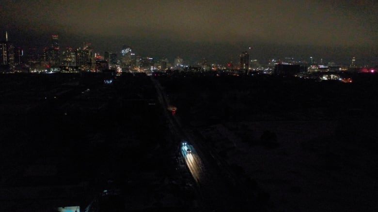 Vehicles drive down East 7th Street as power outages continue to darken most of East Austin, Texas on Wednesday, Feb. 17, 2021. 