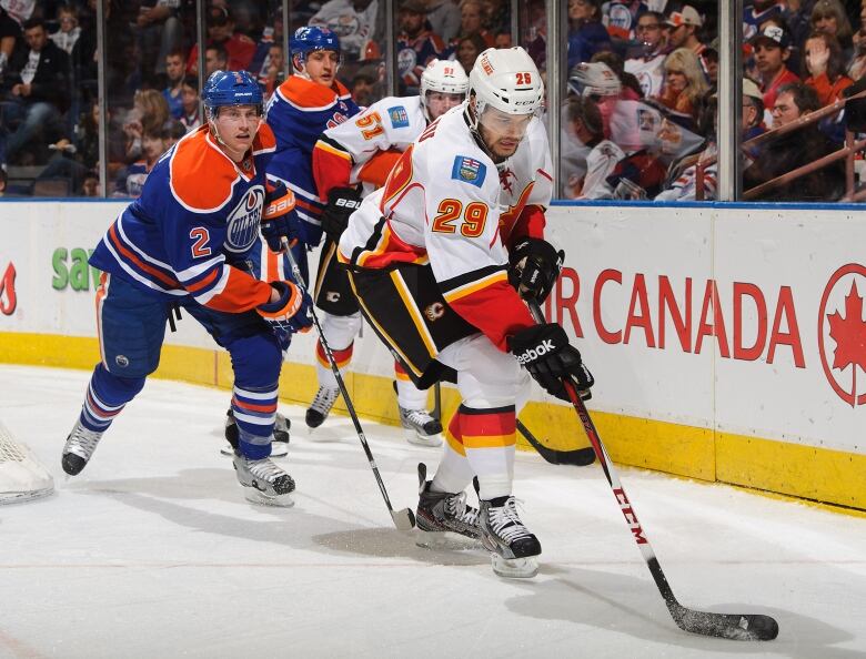 A group of hockey players from two different teams skate during a hockey game.