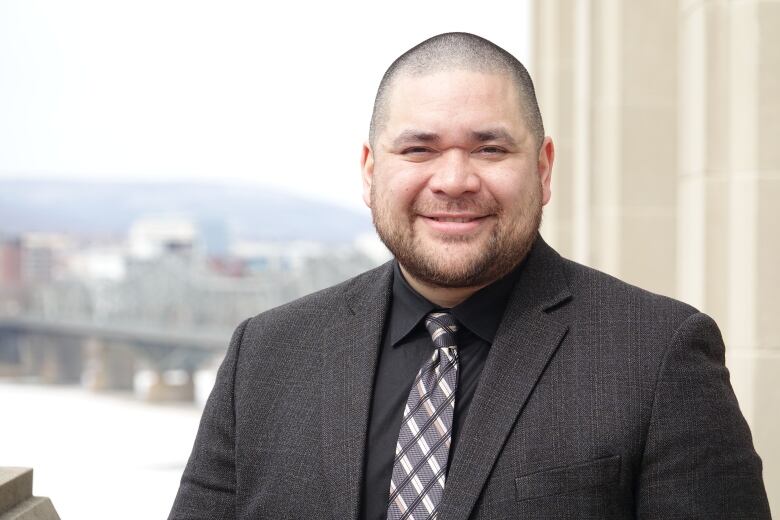 A man wearing a suit smiles.