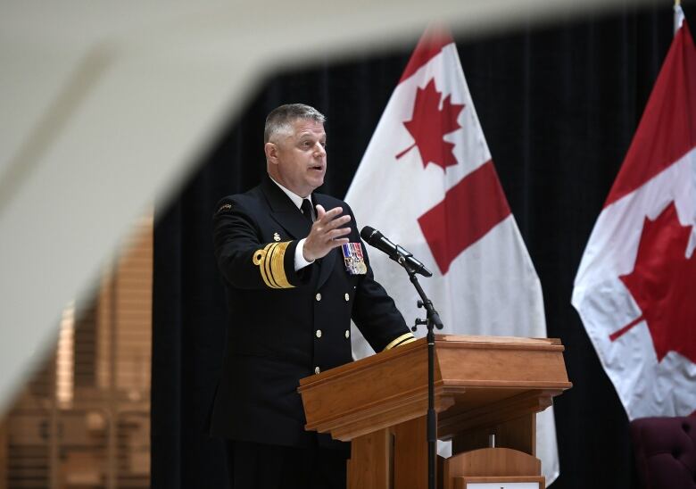 A man in a military uniform gestures while making a speech.