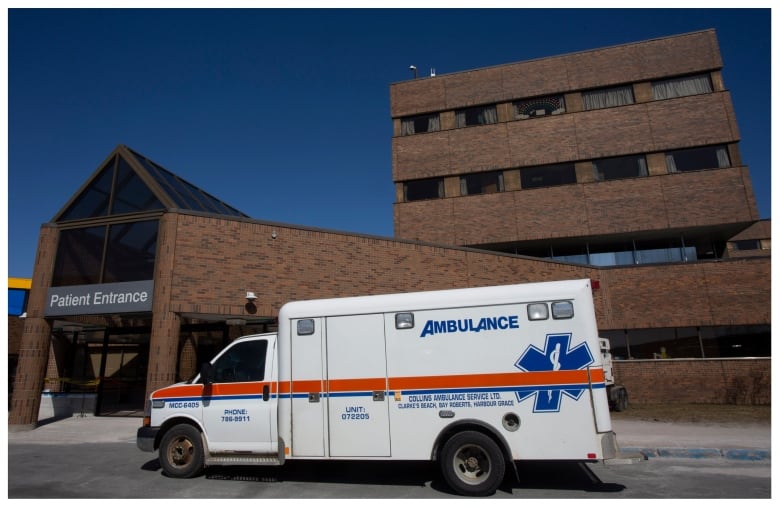 An ambulance outside of a hospital entrance.