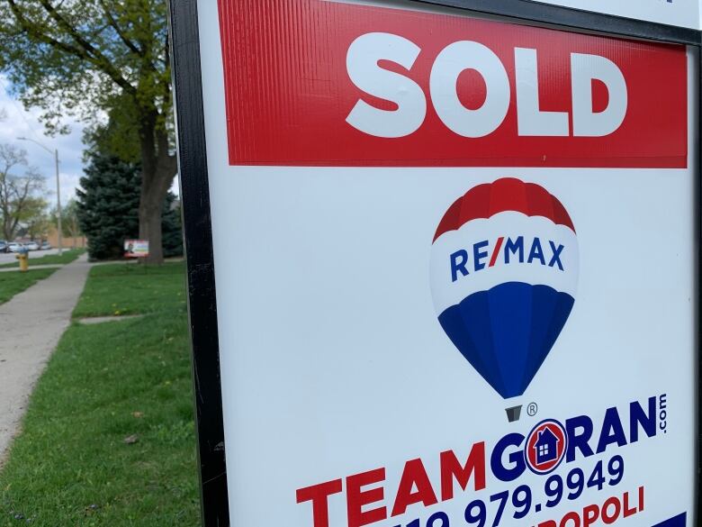 A sold sign sits on a green lawn in Windsor.