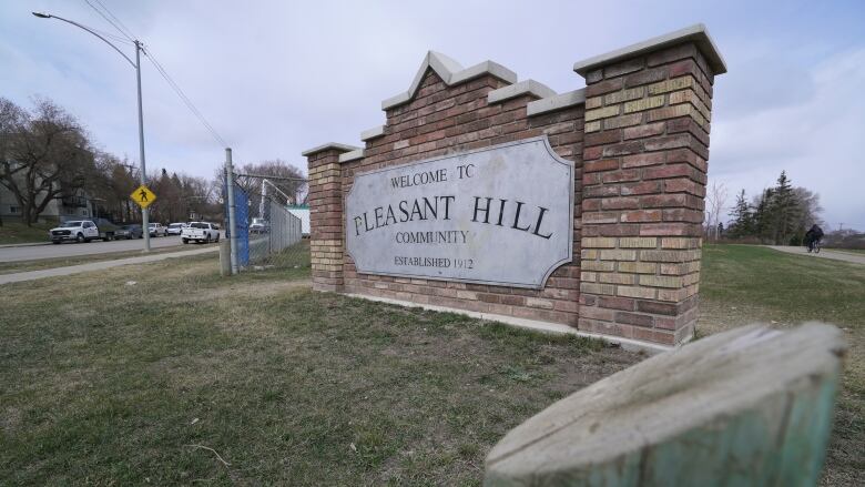 A large brick sign sitting in a field reads pleasant hill in large lettering