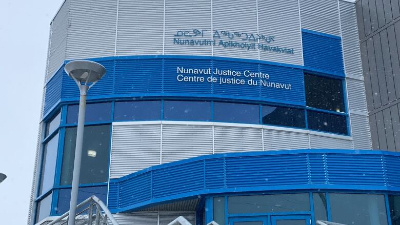 Blue and silver exterior of large building in snow. 