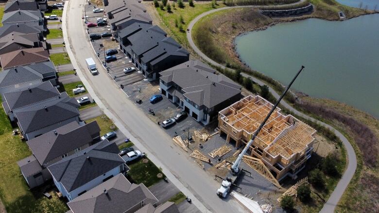 An aerial shot of several homes on a suburban street, one of which is under construction.