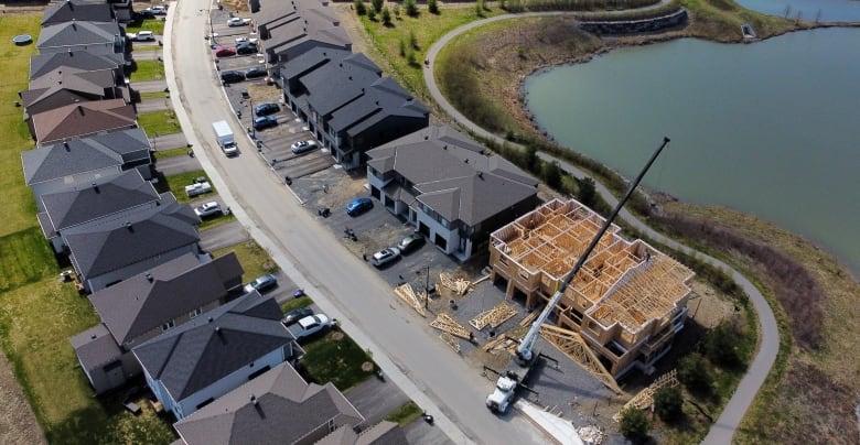 An aerial shot of several homes on a suburban street, one of which is under construction.