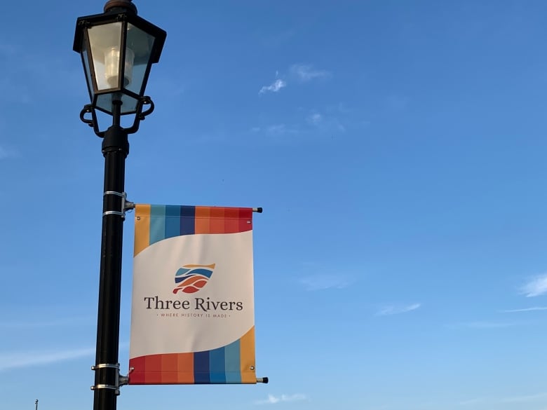 A banner on a light pole with a blue sky in the background.