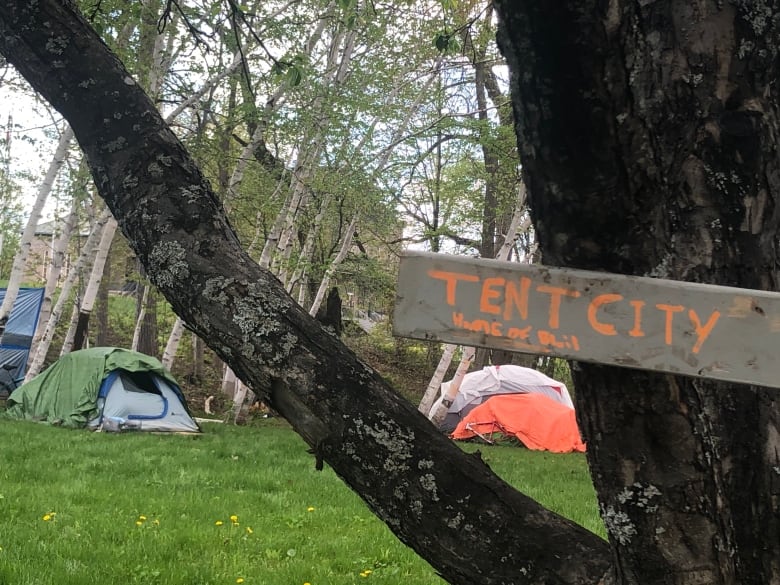 A sign says 'tent city' where an encampment of tents formed in Fredericton.