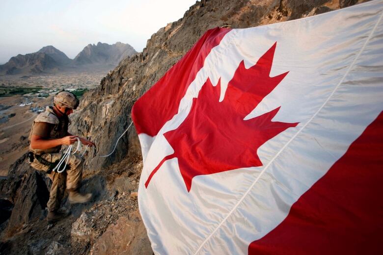 Jeff Wright is seen marking Canada Day by hanging the flag on a mountainside above the forward operating base of Ma'sum Ghar on July 1, 2007. Wright was also honouring his father, also a soldier, who served in Bosnia and gave the flag to his son to take to Afghanistan.