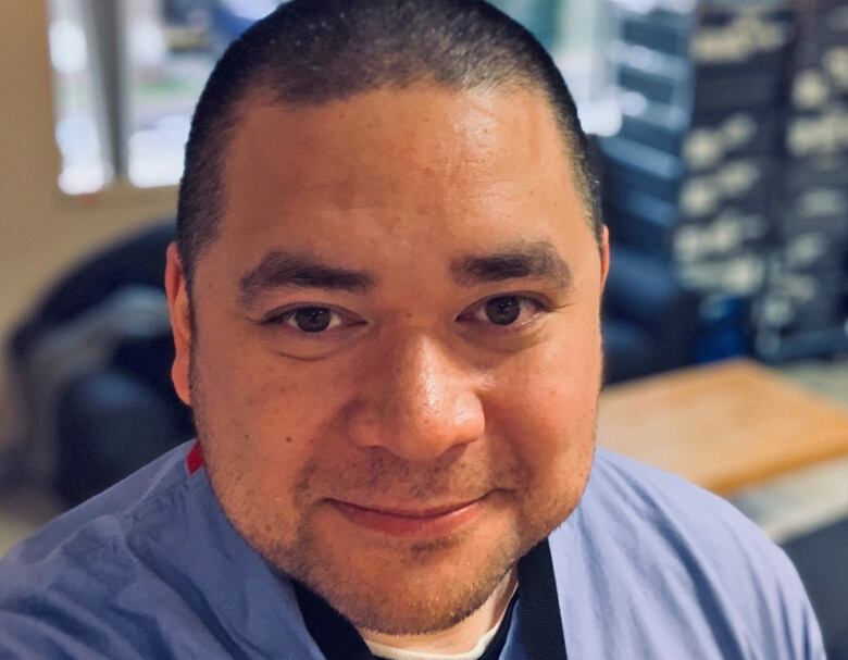 Man in blue medical scrubs with a stethoscope. 