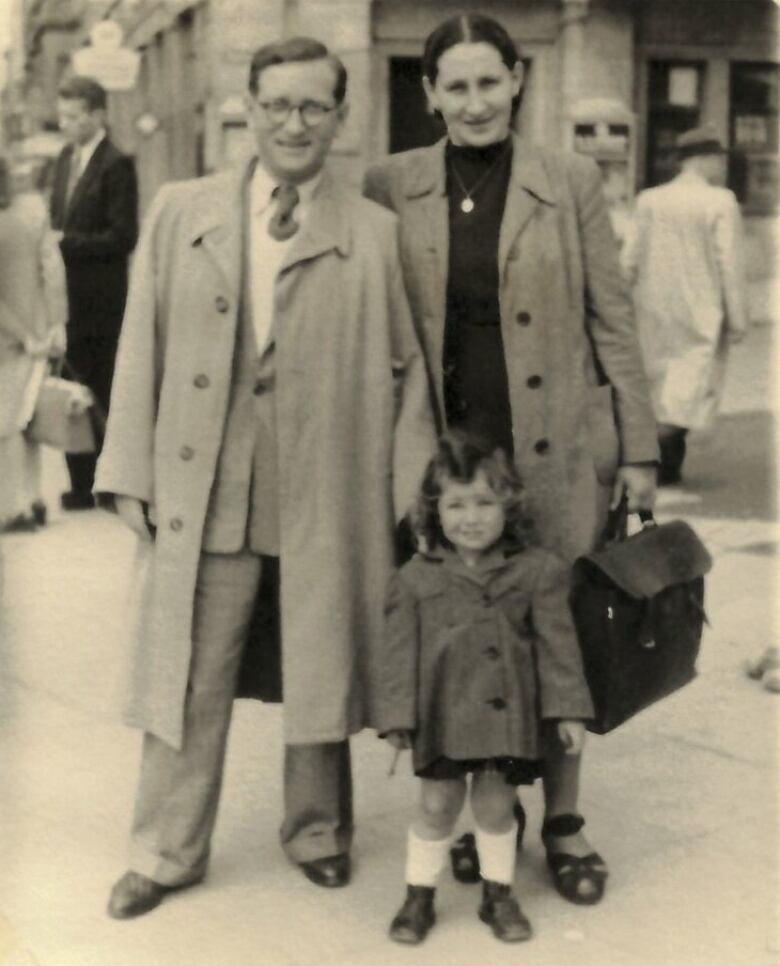 A sepia-toned picture of Rosalie Abella, at about two-years-old, standing in front of her parents in Germany, where they lived before moving to Canada.