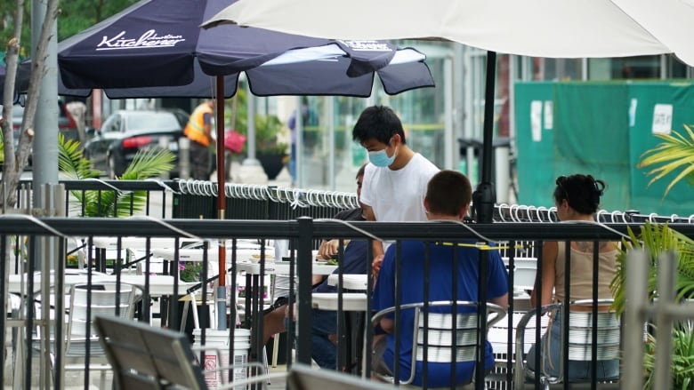 A waiter takes a couple's order on a patio in downtown Kitchener.                      