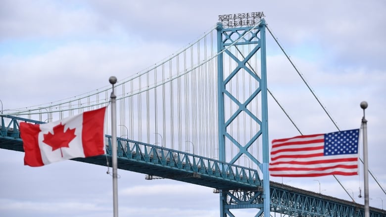 A bridge with a Canadian flag and American flag.