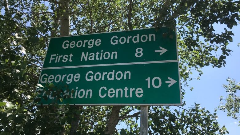 A green signboard showing the way to George Gordon First Nation. 