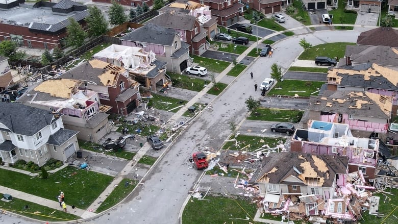 A drone shot shows damaged homes in Barrie, surrounded by debris. 