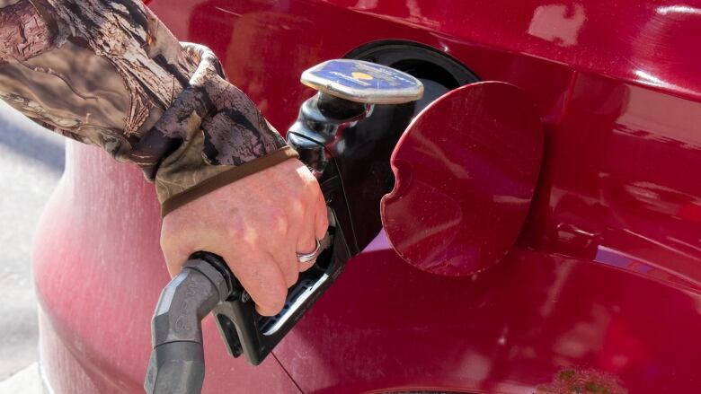 A man pumping gas.