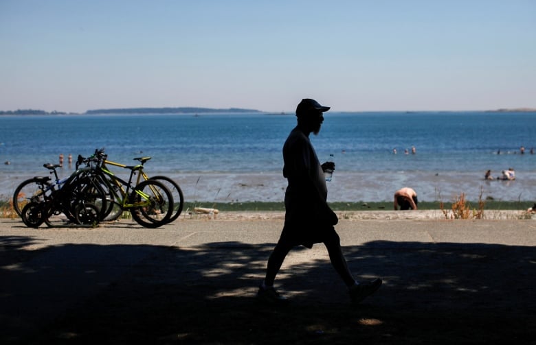 A man walks along Willows Beach during the 