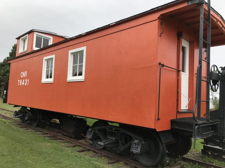 A orange caboose with CNR written on the side