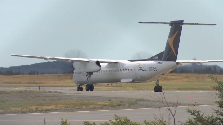 A grey airplane turns on a runway. 