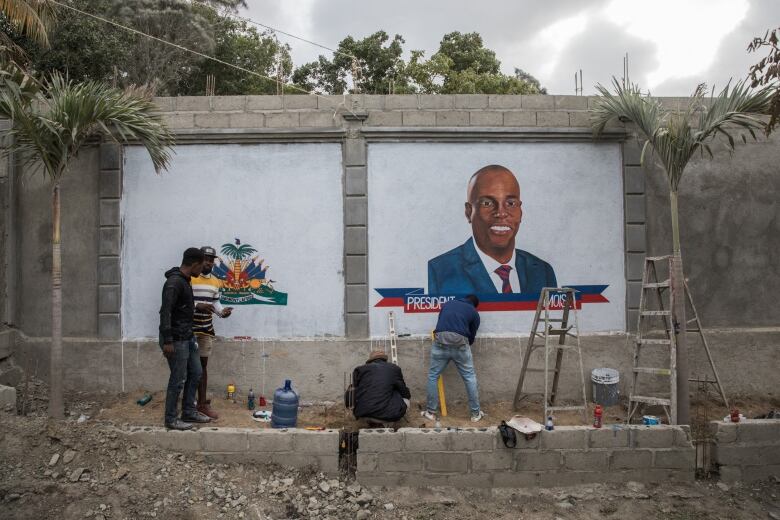 Artists paint a mural.