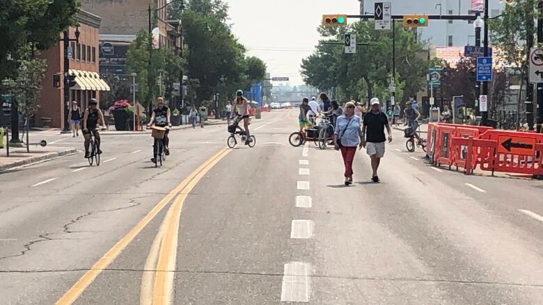 An open road is pictured with pedestrians and cyclists.