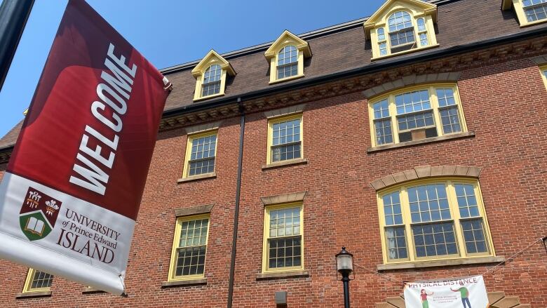 UPEI main building with welcome flag out front.