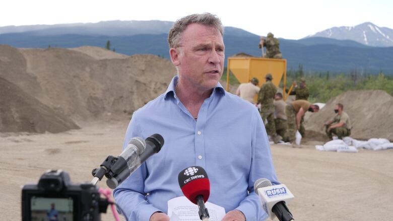 Man standing infront of Canadian militar personnel 