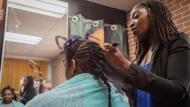 Woman braids hair.