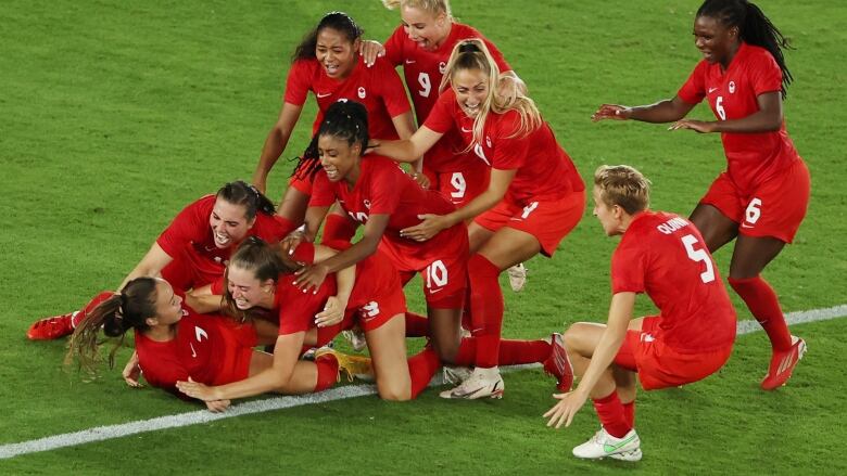 Julia Grosso of Canada celebrates with teammates after scoring the winning penalty in the shootout of the gold medal game at the Tokyo Olympics.